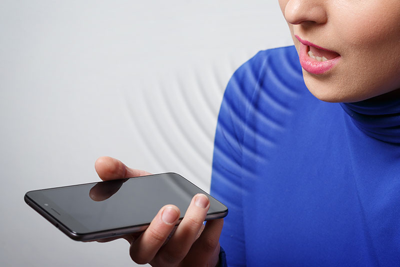 woman using voice search with website on mobile phone